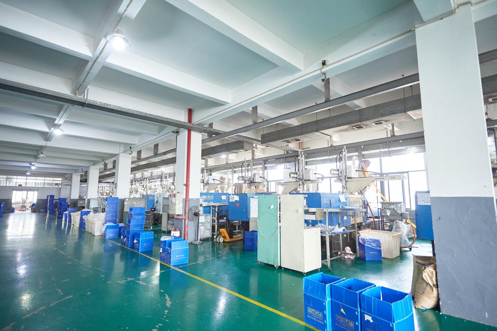 Injection moulding hall with machines, material hoppers and 5S containers